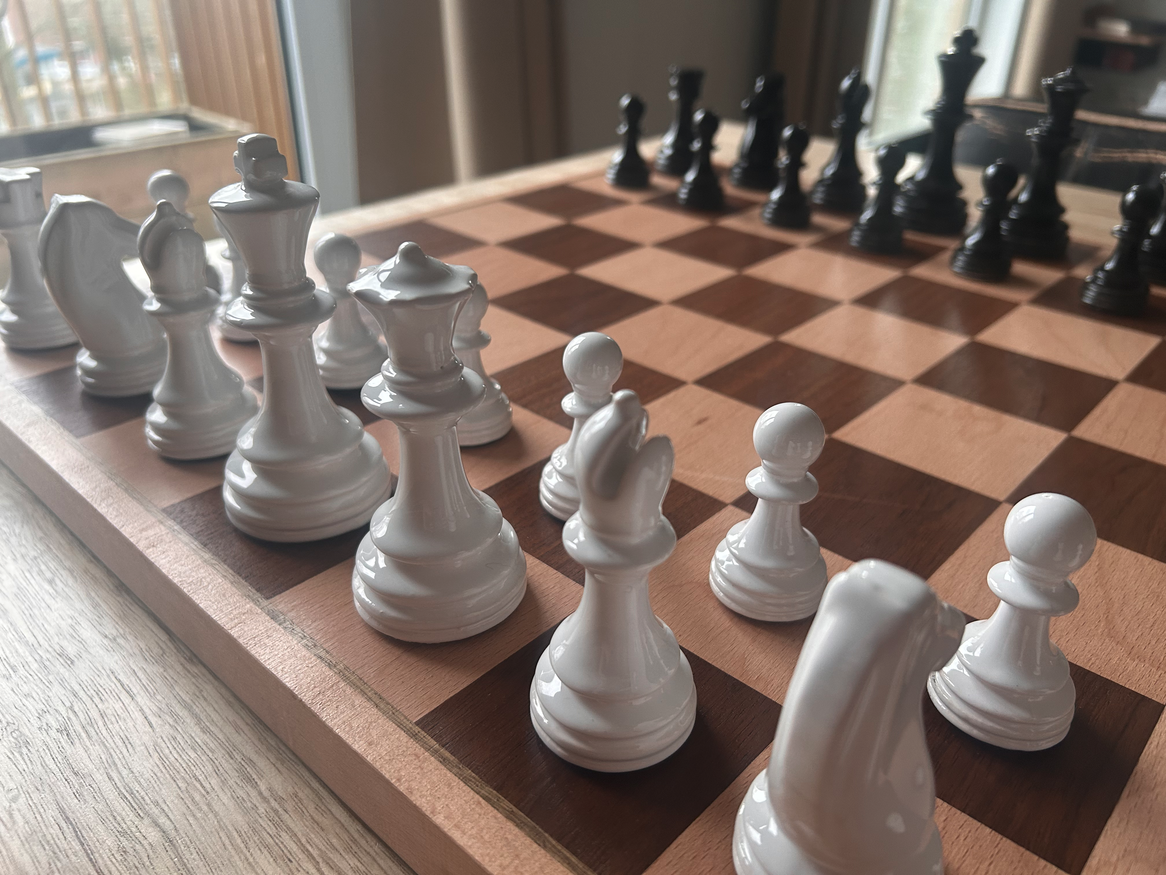 A slipcast chess set on a wooden chess board